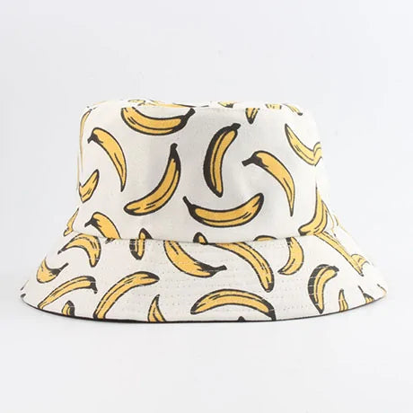 White bucket hat with an all-over yellow banana print outlined in black, shown on a light background.