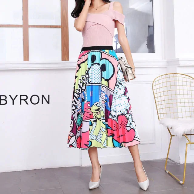 Pleated midi skirt with a gradient design, transitioning from dark black at the waistband to a soft blush pink at the hem, hanging on a black clothing rack next to a vintage-style camera.