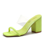 Lime green heeled mule sandal with a square toe, a thin front strap, and a clear vinyl strap across the instep, featuring a chunky block heel.
