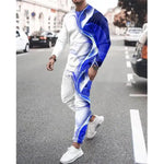 A man wearing a blue and white athletic tracksuit with abstract blue patterns, walking on a city street, paired with white sneakers.
