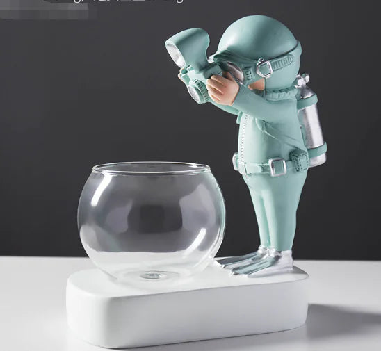 Mint green diver figurine ornament with a round clear glass bowl on a white base.
