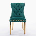 Green velvet chair with gold nailhead trim on a white background
