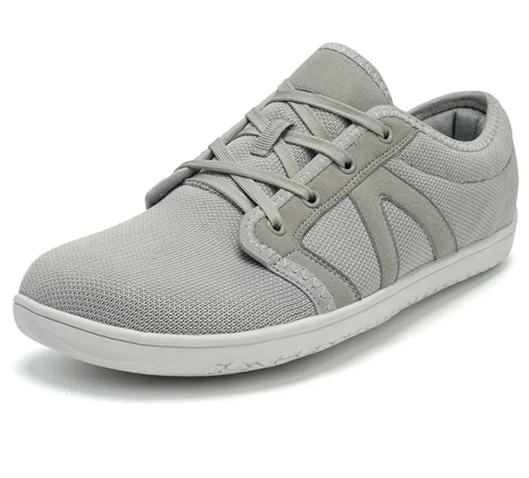Gray-colored casual sneaker with a mesh fabric upper, lace-up design, black eyelets, and a white rubber sole.