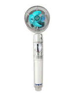 A handheld shower head with a clear round face showing a small blue turbine/fan inside, attached to a transparent handle on a white background.