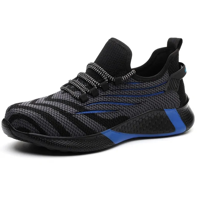 A black and dark gray athletic sneaker with a breathable knit upper, accented by bold orange wave-like stripes on the sides and orange detailing on the midsole. The shoe features a thick, textured sole and black-and-white patterned laces, designed for both style and performance.