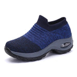 A vibrant red athletic sneaker featuring a breathable knit upper, lace-up design, and a unique, futuristic sole with hollowed cushioning pods for enhanced flexibility and support.