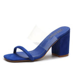 A blue heeled slide sandal with a clear vinyl upper strap, a toe loop front strap, square open toe, and a chunky block heel.