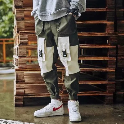 Olive green cargo joggers with contrast cream utility pockets, elastic cuffs and a relaxed streetwear fit.
