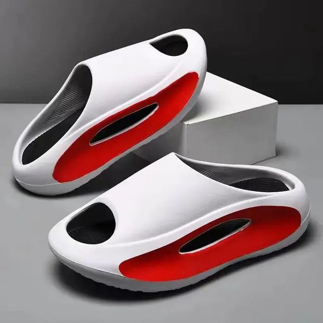 A pair of stylish black slip-on sandals with purple cushioned insoles, featuring cutout designs on the sides and toes, displayed on a white surface next to stacked books.
