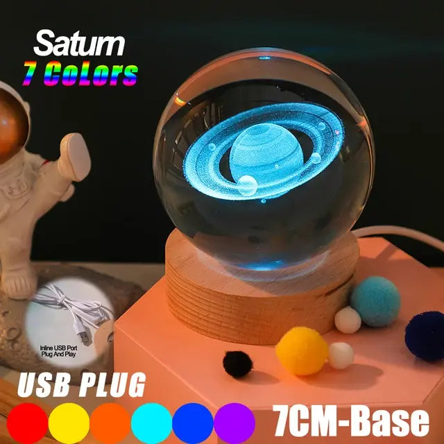 Glowing crystal ball night light with a 3D Saturn design inside, sitting on a wooden base, with text advertising “Saturn 7 Colors,” “USB PLUG,” and a “7CM-Base.