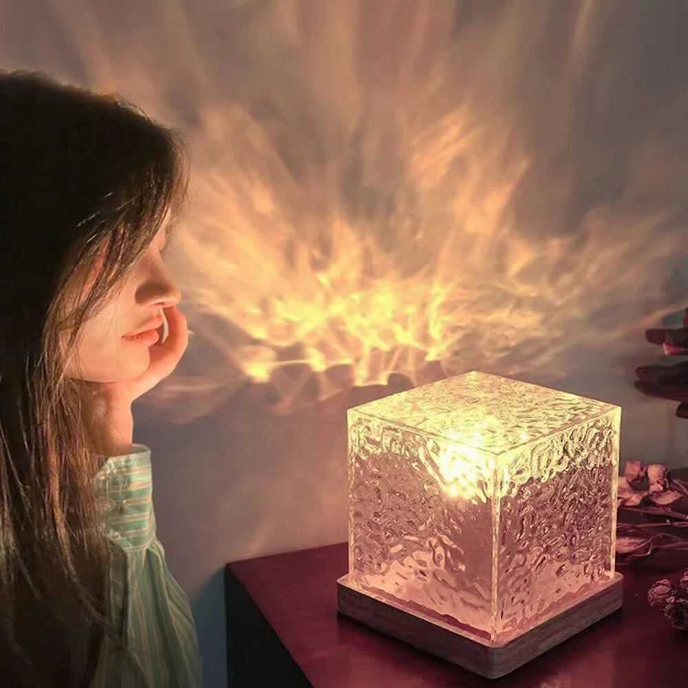 Glowing cube table lamp casting warm light patterns on the wall.