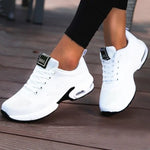 A black and dark gray athletic sneaker with a breathable knit upper, accented by bold orange wave-like stripes on the sides and orange detailing on the midsole. The shoe features a thick, textured sole and black-and-white patterned laces, designed for both style and performance.