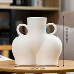 White ceramic body-shaped decorative vase with twin handles and rounded sculptural form.
