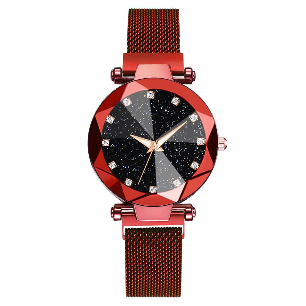 Red metal mesh-band wristwatch with a faceted red bezel and a black starry dial, featuring crystal-style hour markers and gold hands, on a white background.