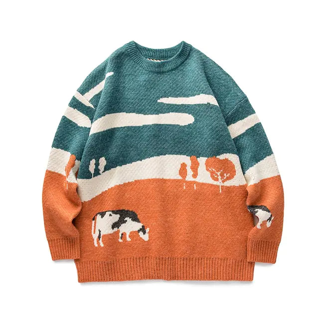 A cozy crewneck knit sweater featuring a scenic countryside design. The upper half is teal-blue with white cloud-like stripes, while the lower half is warm rust orange with white and black grazing cows and small tree motifs. It has long sleeves, a relaxed fit, and ribbed cuffs, neckline, and hem for a snug finish.