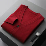 A neatly fold shirt on a black box with a black leather watch beside it