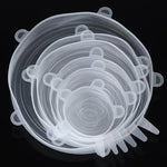Set of clear silicone stretch lids in multiple sizes, stacked together on a dark background, with pull tabs visible around the edges.