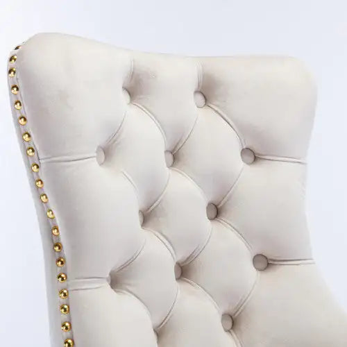 White tufted headboard with gold nailhead trim on a white background