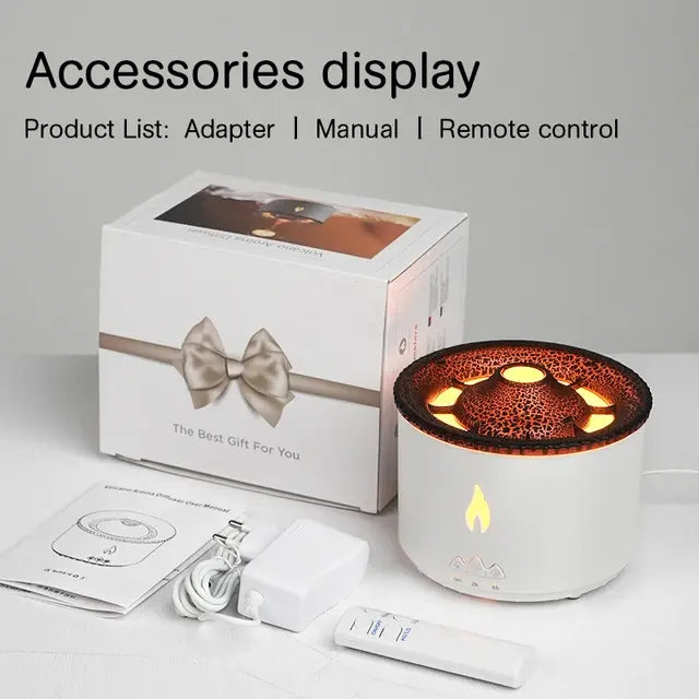 A white aromatherapy diffuser with a glowing flame design on the front, accompanied by a box, remote control, adapter, and user manual, placed on a white surface.