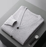 A neatly fold shirt on a black  surface with a black leather wrist-watch beside it
