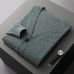A neatly fold shirt on a black box with a black leather watch beside it