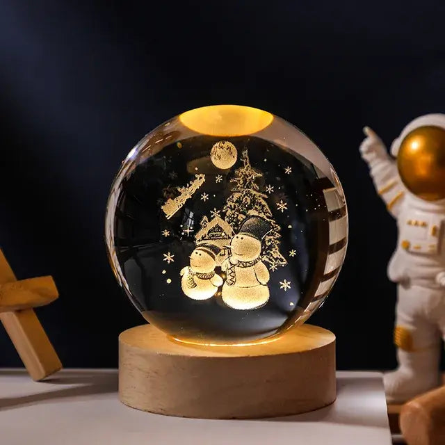 A glowing crystal ball lamp with a golden spiral galaxy design inside sits on a wooden base, softly illuminated, with a small astronaut figurine standing in the background against a dark backdrop.