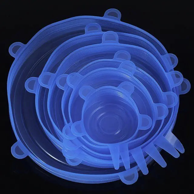 Set of translucent blue silicone stretch lids in multiple sizes, stacked together on a black background, each with small pull tabs around the edge.