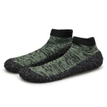 A pair of snug slip-on water shoes with a sock-like upper in a green and black heathered knit pattern. They feature black ankle cuffs and textured black rubber-coated soles that wrap around the sides for added grip and protection.