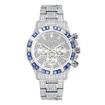 Silver-tone luxury watch covered with diamonds and blue gemstones around the bezel, featuring a chronograph design with multiple sub-dials, shown on a white background.