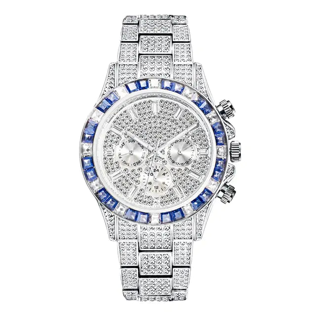 Silver-tone luxury watch covered with diamonds and blue gemstones around the bezel, featuring a chronograph design with multiple sub-dials, shown on a white background.