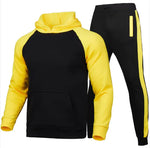 A stylish two-piece men's tracksuit. The set includes a hooded sweatshirt with a kangaroo pocket and long gray sleeves, along with matching jogger pants that have a drawstring waist and gray side panels with zippered pockets. The design offers a sporty yet casual look, ideal for workouts or everyday wear.