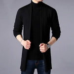 Black open-front cardigan layered over a black roll-neck jumper and jeans.
