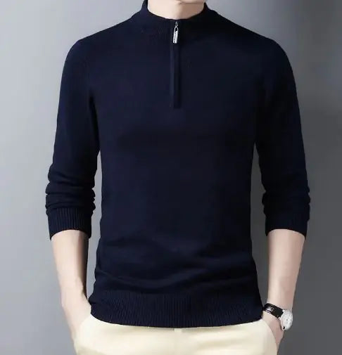 A stylish black slim-fit sweater with a quarter-zip collar, worn by a male model against a neutral gray background. The sweater has a ribbed hem and cuffs, giving it a sleek and fitted appearance. The model is also wearing light-colored trousers and a silver wristwatch, adding a touch of sophistication to the outfit.