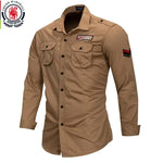 A military-inspired khaki long-sleeve button-up shirt with black buttons. The shirt features two front chest pockets with flap closures, a 'Marshall Guardian' patch on the right chest, and a red and black chevron patch on the left sleeve. The rugged design and structured fit give it a tactical, adventure-ready look