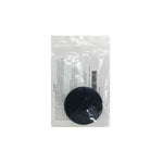 Small round device (possibly a tracker or accessory) inside a clear plastic packaging with product instructions visible behind it.