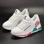 A pair of stylish mesh sneakers worn with jeans. The shoes feature colorful embroidered details The sneakers have a sleek, breathable design and a casual, trendy aesthetic.