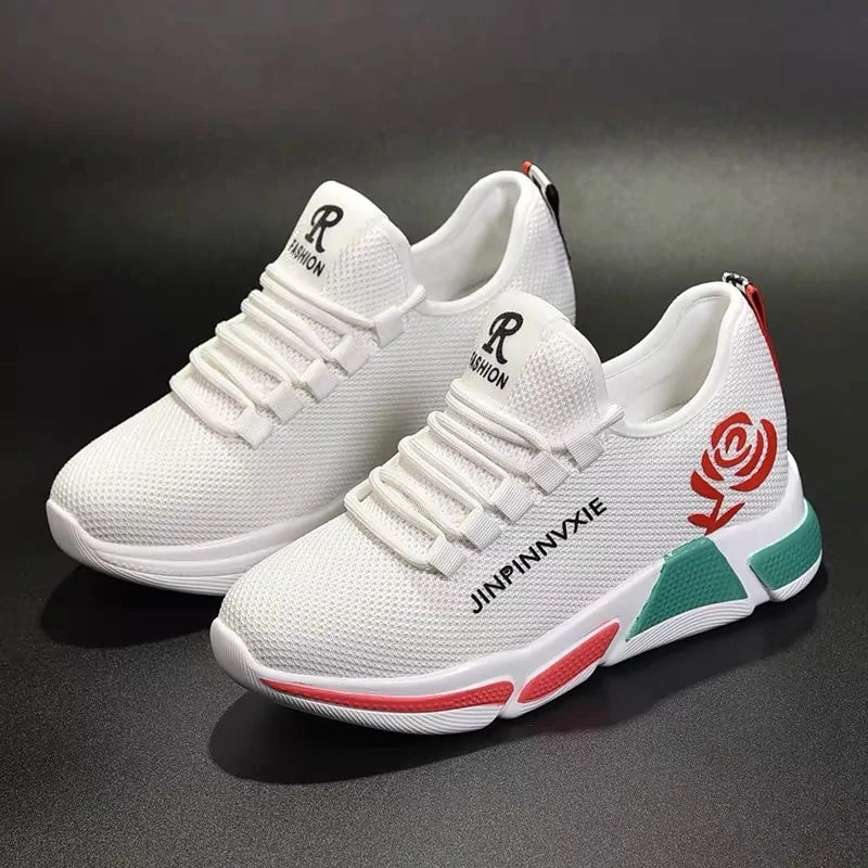 A pair of stylish mesh sneakers worn with jeans. The shoes feature colorful embroidered details The sneakers have a sleek, breathable design and a casual, trendy aesthetic.