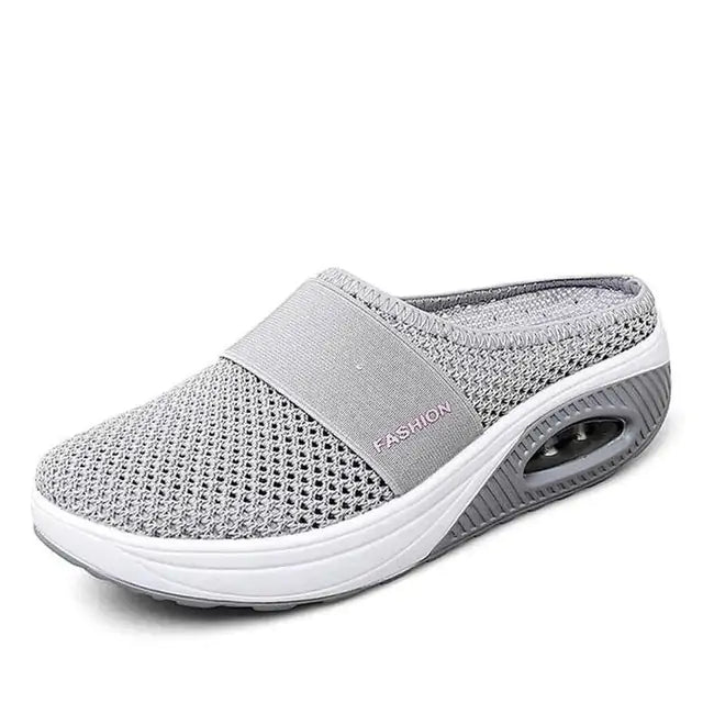 A single gray slip-on mesh sneaker with a white sole and air-cushion heel, featuring a breathable upper, an elastic band across the top for support, and the word “FASHION” printed on the side.