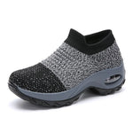A vibrant red athletic sneaker featuring a breathable knit upper, lace-up design, and a unique, futuristic sole with hollowed cushioning pods for enhanced flexibility and support.