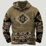A brown pullover hoodie with a rustic southwestern-inspired design, featuring a drawstring hood, large front kangaroo pocket, and bold geometric tribal-style patterns on the sleeves and pocket. The chest has a central embroidered-style motif in black, cream, and orange, giving the hoodie a cozy, vintage outdoor look against a plain light background.