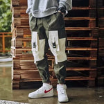 Men’s colour-block cargo joggers with buckle pockets.
