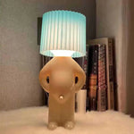 Cute character-shaped table lamp with blue pleated shade.
