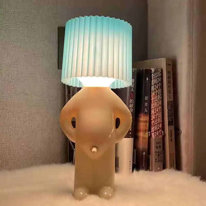 Cute character-shaped table lamp with blue pleated shade.

