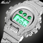 Close-up of a silver-tone digital wristwatch covered in rhinestones, with a green backlit display and three green accent circles above it; “Miss fox” logo appears in the top left on a dark background.