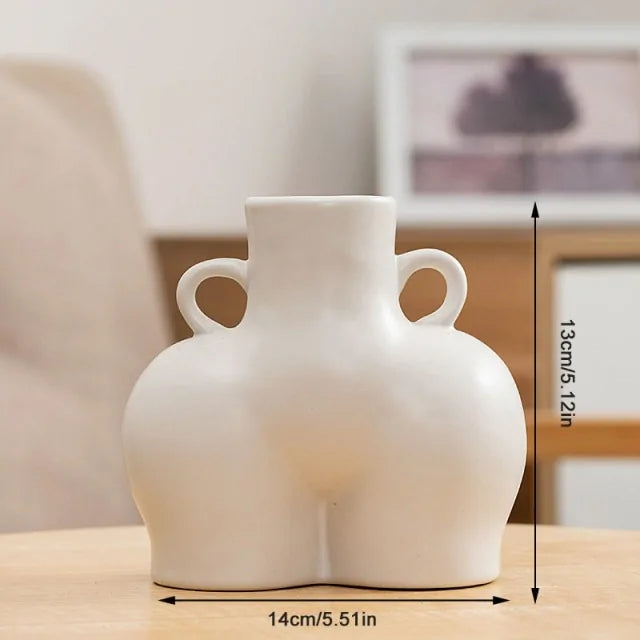 White abstract ceramic vase with a sculptural body-shaped design and twin loop handles.