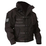 Black tactical-style jacket with a high collar, front zipper, multiple buckle straps across the chest, and sleeve patches, shown on a white background.