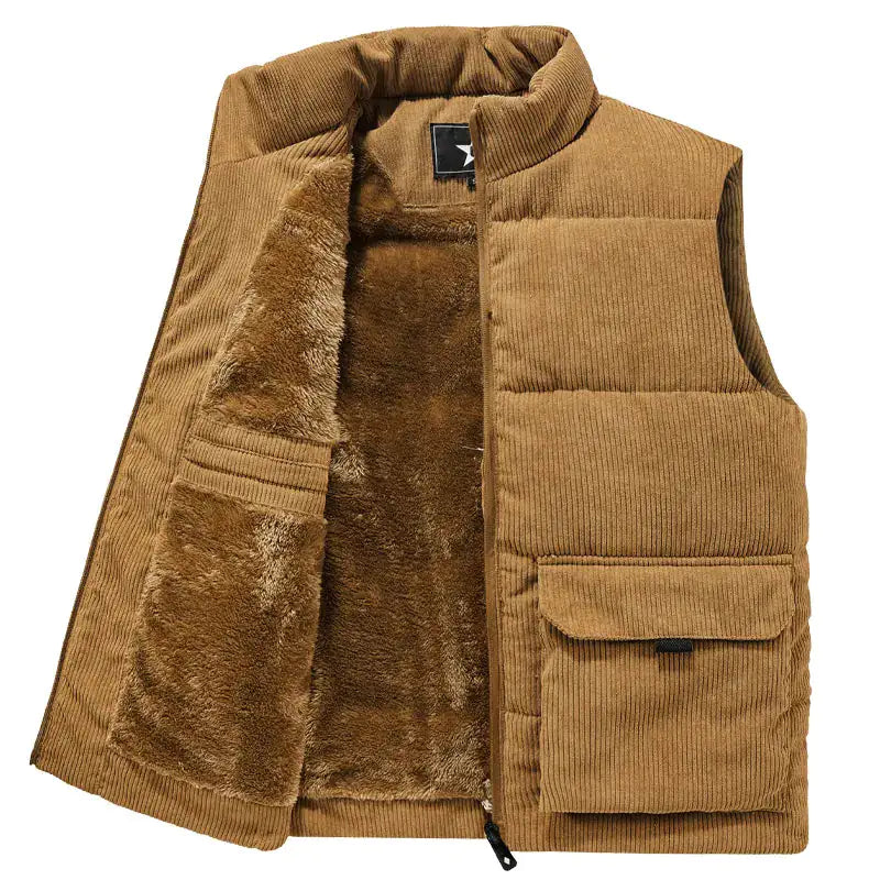 A stylish sleeveless puffer vest made of soft corduroy fabric. The vest features a high collar for added warmth and a cozy fleece lining. It has two large front pockets with flap closures, adding both functionality and a rugged aesthetic. The vest is open in the image, showcasing the plush inner lining