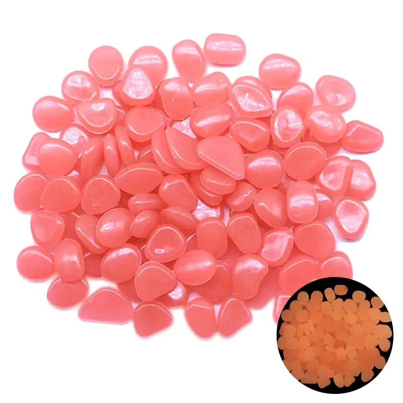Pile of small translucent light-pink glow pebbles on a white background, with an inset showing them glowing bright green in the dark.