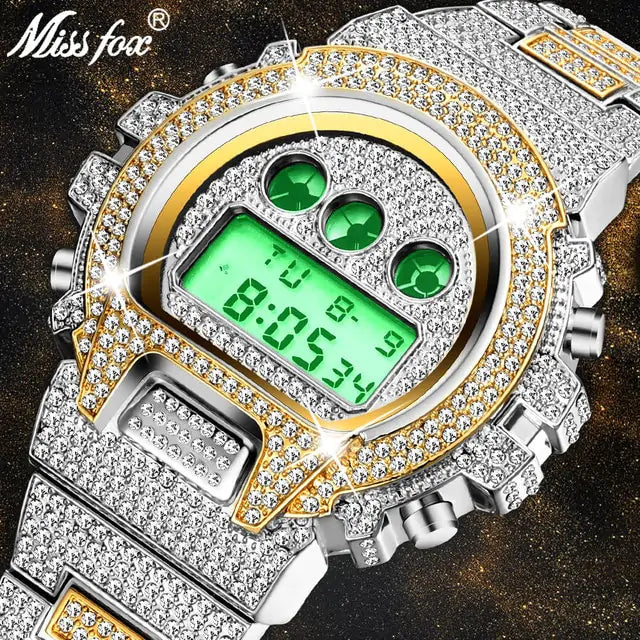 Close-up of a silver and gold-tone digital wristwatch encrusted with rhinestones, featuring a green backlit display and three green circular accents above the screen; “Miss Fox” logo appears in the top-left corner.
