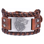 brown leather cuff bracelet featuring a silver Viking wolf head emblem in the center, surrounded by braided leather detailing and metal studs on each side.